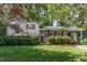 Charming two-story home featuring a lush green lawn, brick accents, and a convenient covered carport at 612 Locust Ln, Raleigh, NC 27603