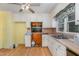 Outdated kitchen with white cabinets, wood-look floor, and a window above the sink at 612 Locust Ln, Raleigh, NC 27603