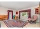 Bright living room with a patterned rug, glass table, piano, and cozy armchair at 612 Locust Ln, Raleigh, NC 27603