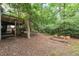 Spacious backyard with a deck, mature trees, and a vintage gardening frame at 616 Cross Timbers Dr, Durham, NC 27713