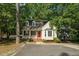 Charming home featuring a red door, dormer windows, and a cozy front porch surrounded by lush trees at 616 Cross Timbers Dr, Durham, NC 27713
