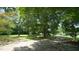 Mature trees and a dirt driveway grace the backyard at 6600 Sadie Dr, Wendell, NC 27591