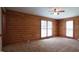 Spacious bedroom features log walls, neutral carpet and three windows for ample natural light at 6600 Sadie Dr, Wendell, NC 27591