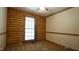 Cozy bedroom featuring a wood accent wall, ceiling fan, and natural light at 6600 Sadie Dr, Wendell, NC 27591