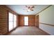 Bright bedroom offers natural log walls, neutral carpet, and two large windows for natural light at 6600 Sadie Dr, Wendell, NC 27591
