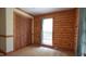Bedroom with carpeted floors, a window with blinds, and a wood paneled accent wall at 6600 Sadie Dr, Wendell, NC 27591