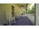 Spacious covered porch with rocking chairs, ceiling fan, and outdoor seating at 6600 Sadie Dr, Wendell, NC 27591