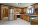 Full kitchen view featuring wooden cabinets, stainless steel refrigerator, and tile flooring at 6600 Sadie Dr, Wendell, NC 27591