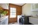 Laundry room featuring a modern washer and dryer, sink, and wooden wall at 6600 Sadie Dr, Wendell, NC 27591