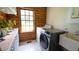 Bright laundry room with modern washer and dryer and white cabinetry and tiled floor at 6600 Sadie Dr, Wendell, NC 27591