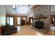Comfortable living room featuring a stone fireplace, hardwood floors, log walls, and natural light at 6600 Sadie Dr, Wendell, NC 27591