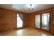 Comfortable living area with log walls, hardwood floors, and natural light from the windows at 6600 Sadie Dr, Wendell, NC 27591