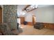 Open living room featuring a stone fireplace, wood floors, vaulted ceilings, and abundant natural light at 6600 Sadie Dr, Wendell, NC 27591