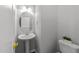 Bright powder room featuring a pedestal sink, decorative mirror, and neutral paint at 6809 Middleboro Dr Dr, Raleigh, NC 27612