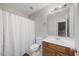 Clean bathroom with white tile, a wooden vanity, and a shower with a white curtain at 82 Finley Ct, Clayton, NC 27520