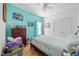 Bright bedroom featuring cool-toned accent wall, neutral bedding, ceiling fan, and decorative artwork at 82 Finley Ct, Clayton, NC 27520