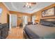 Spacious bedroom with a tray ceiling, ceiling fan, wood floors, and TV at 82 Finley Ct, Clayton, NC 27520