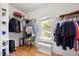 Organized walk-in closet with wire shelving, hardwood floors, and natural light from the window at 82 Finley Ct, Clayton, NC 27520