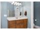 Bathroom features a wood vanity cabinet with a marble countertop and a large framed mirror at 9048 Chelsea Dr, Raleigh, NC 27603