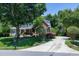 Charming two-story brick home with a lush front yard, a long driveway and mature trees at 9048 Chelsea Dr, Raleigh, NC 27603