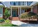 Inviting front porch with brick columns, detailed trim, and a decorative glass front door at 9048 Chelsea Dr, Raleigh, NC 27603