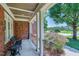 Relaxing covered front porch with seating, offering a peaceful view of the landscaped yard at 9048 Chelsea Dr, Raleigh, NC 27603