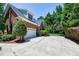 Side view of brick house with a two-car garage and long driveway with surrounding trees at 9048 Chelsea Dr, Raleigh, NC 27603
