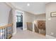 Upstairs hallway with neutral carpeting and railings offering views to the bedrooms at 9048 Chelsea Dr, Raleigh, NC 27603