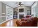 Cozy living room featuring a fireplace, hardwood floors, and access to the outdoor patio at 9048 Chelsea Dr, Raleigh, NC 27603