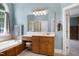 This bathroom has a tub, shower, and vanity with mirror and great lighting at 9048 Chelsea Dr, Raleigh, NC 27603