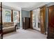 The main bedroom features a four poster bed, natural light, and sitting area at 9048 Chelsea Dr, Raleigh, NC 27603