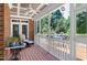 This screened porch has wood floors, brick columns, white railing and ceiling fan at 9048 Chelsea Dr, Raleigh, NC 27603