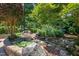 A serene water feature with rocks and plantings creates a tranquil and picturesque focal point in the backyard at 9048 Chelsea Dr, Raleigh, NC 27603