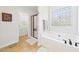 Bathroom boasting a bathtub, glass shower, and a decorative window at 100 S Sunset Ridge Dr, Willow Springs, NC 27592