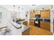 Well-lit kitchen featuring wood cabinets, black appliances, and a bar overlooking the dining area at 100 S Sunset Ridge Dr, Willow Springs, NC 27592