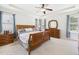 Spacious main bedroom featuring a tray ceiling, carpeted floors, and natural light from large windows at 100 S Sunset Ridge Dr, Willow Springs, NC 27592