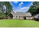 Spacious backyard showcasing a brick and siding home, a manicured lawn, and a wooden deck at 10031 Old Middlesex Rd, Middlesex, NC 27557