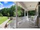 Inviting front porch with white railings, lush greenery, and comfortable rocking chairs at 10031 Old Middlesex Rd, Middlesex, NC 27557