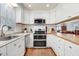 Bright kitchen with stainless steel appliances, butcher block countertops, white cabinets, and hardwood floors at 10031 Old Middlesex Rd, Middlesex, NC 27557