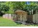 Charming wooden playhouse in a fenced yard with custom details, offering a fun outdoor space at 10031 Old Middlesex Rd, Middlesex, NC 27557