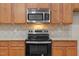 Close up shot of stainless steel microwave and oven in kitchen with granite countertop at 1012 Palace Garden Way, Raleigh, NC 27603