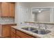 Kitchen sink with wooden cabinets, granite countertops, tile backsplash and stainless steel faucet at 1012 Palace Garden Way, Raleigh, NC 27603