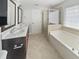 Bright bathroom featuring double sinks, a soaking tub, and a walk-in shower with tiled accents at 1092 Adams Point Dr, Garner, NC 27529