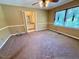 Spacious carpeted bedroom featuring natural light from a large window and ceiling fan at 120 W Front St, Oxford, NC 27565
