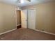 This bedroom includes a closet with white doors and access to other rooms with a neutral carpet at 120 W Front St, Oxford, NC 27565