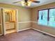 Spacious carpeted bedroom featuring natural light from a large window and ceiling fan at 120 W Front St, Oxford, NC 27565