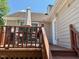 Back deck includes tan siding, a grill, and outdoor furniture on the home's exterior at 120 W Front St, Oxford, NC 27565