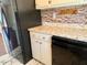 Well-lit kitchen with faux brick backsplash, white cabinets and marbled tile floor at 120 W Front St, Oxford, NC 27565