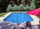 Sparkling in-ground pool surrounded by a concrete deck and privacy landscaping at 120 W Front St, Oxford, NC 27565