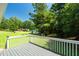 View of the backyard from the deck, featuring mature trees and lush grass at 1201 Teakwood Ct, Sanford, NC 27330
